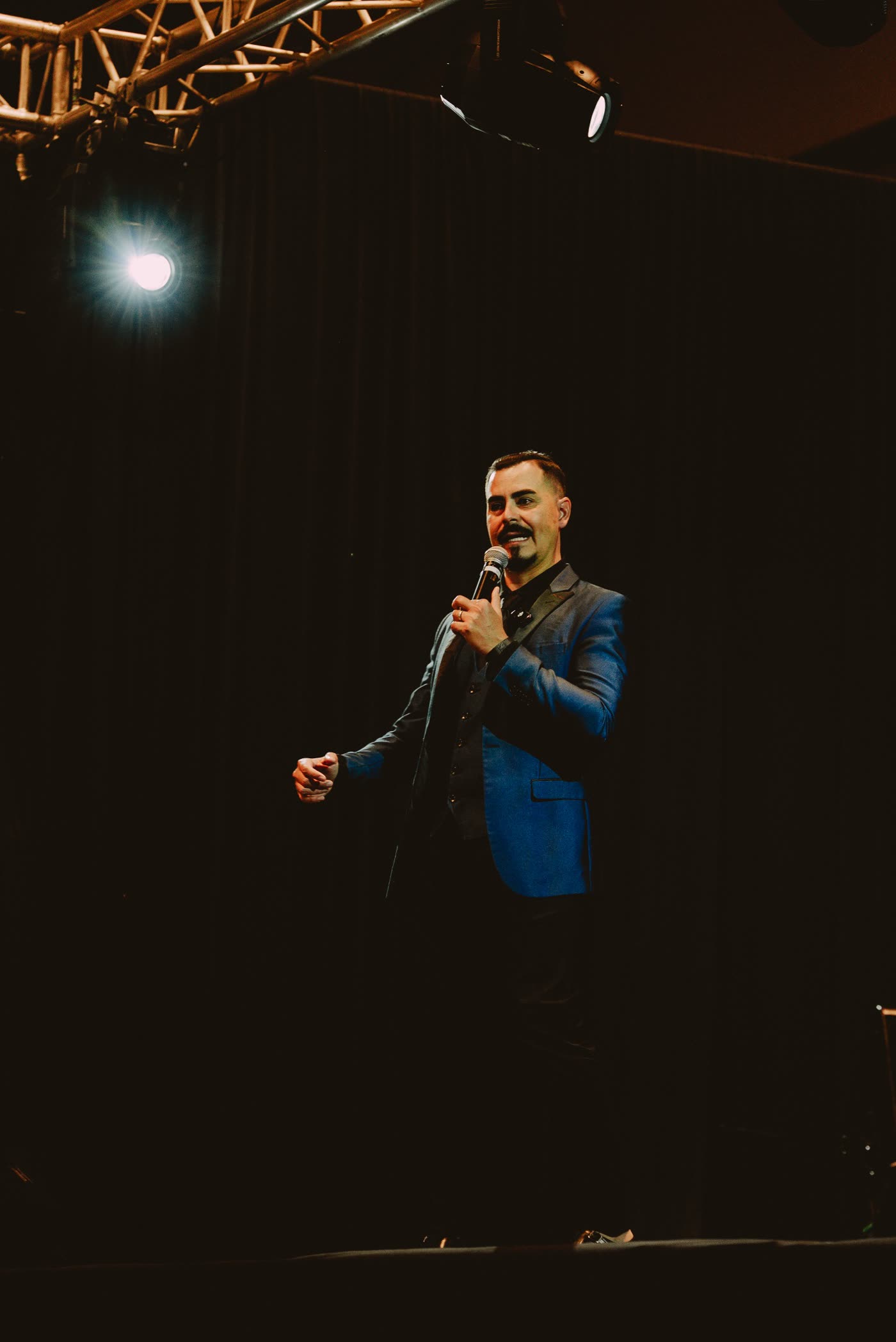 Héctor Quirós en el escenario con micrófono