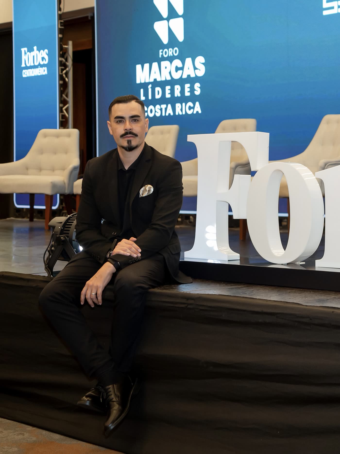 Héctor Quirós sentado en el borde de un escenario